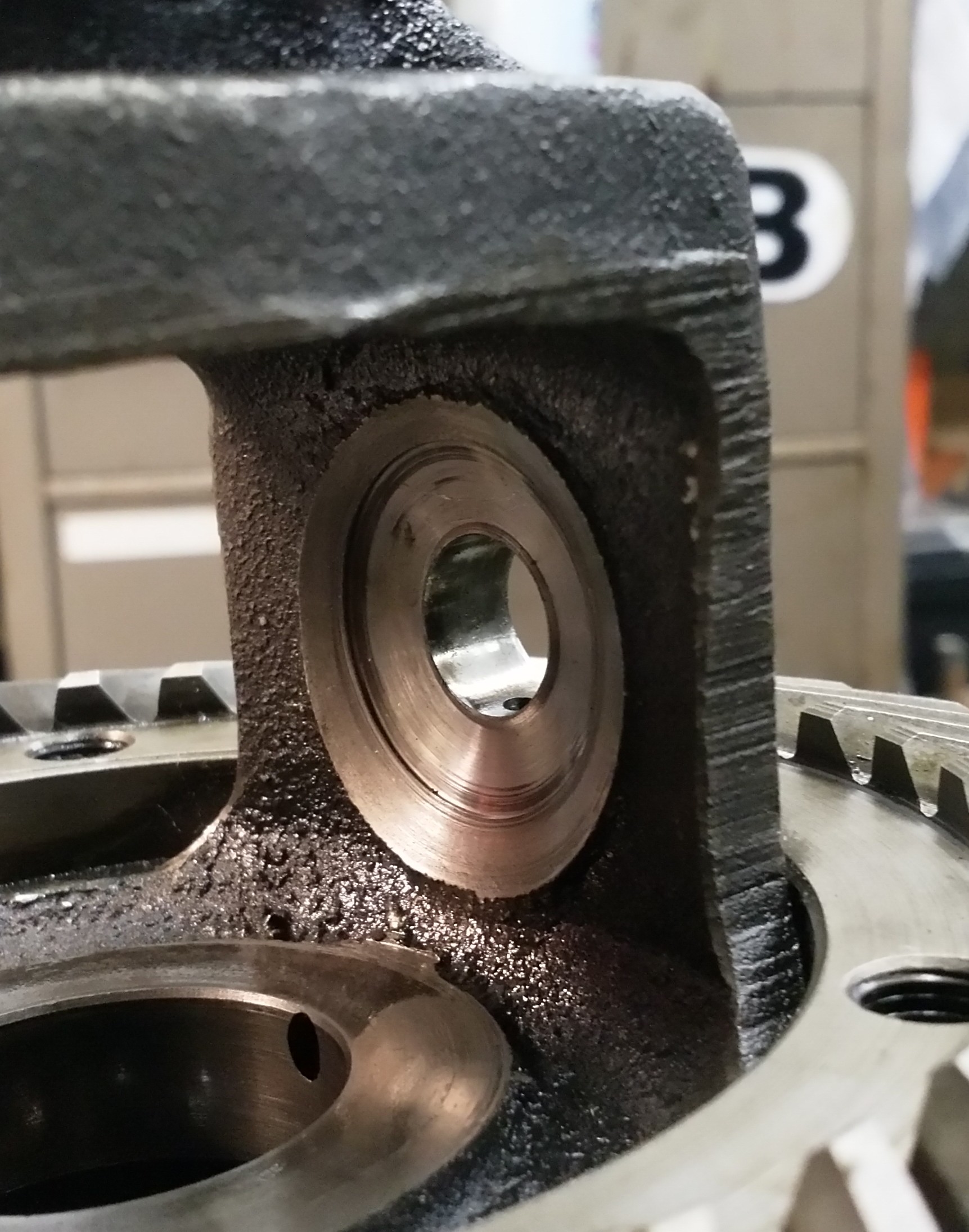 Looking inside the cage, the shaft on which the planet wheels sit runs from left to right, through the hole in the cage. The thrust washer sits between the planet wheel and the cage.