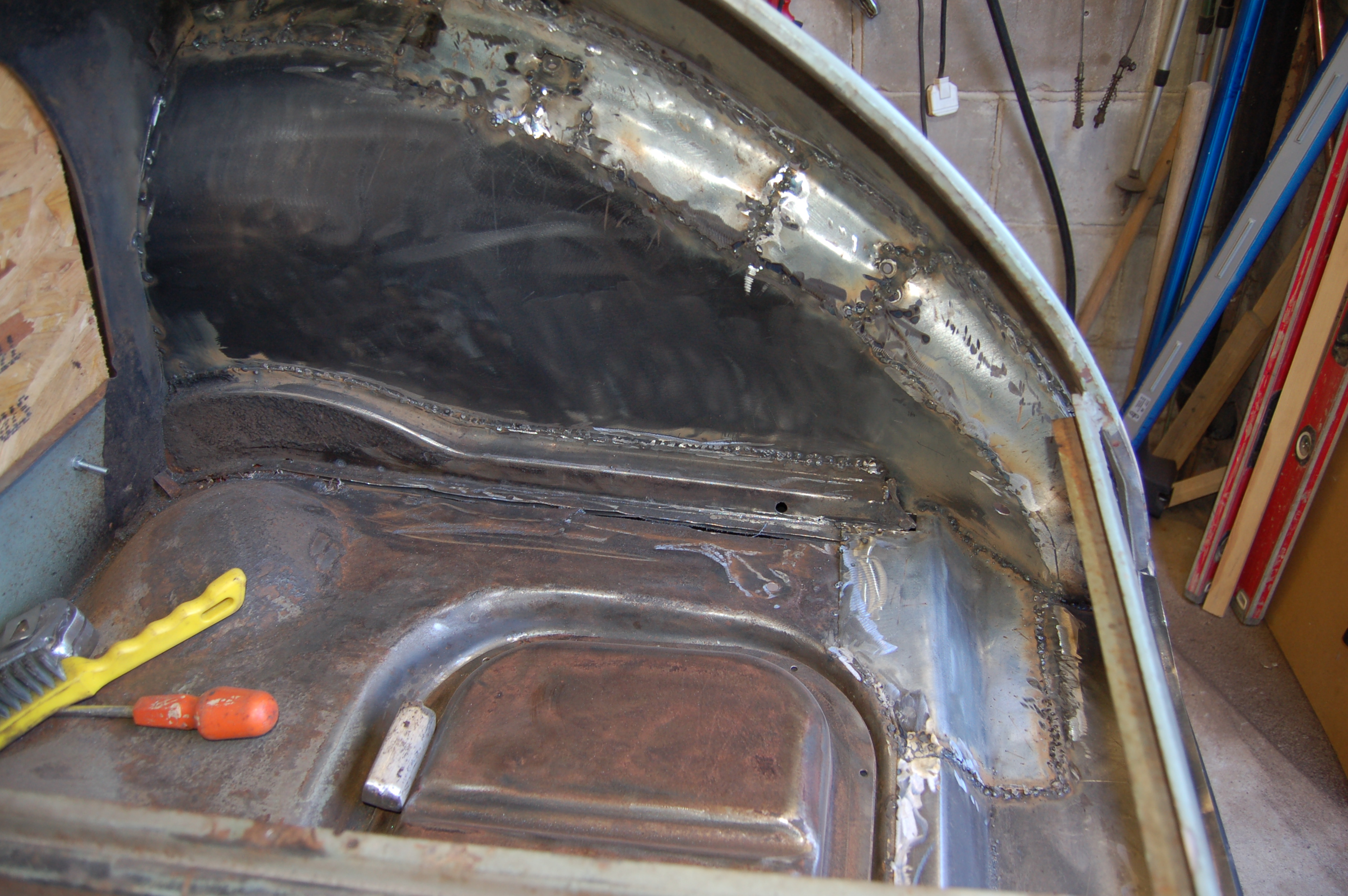 inside boot area showing repair pieces to support wing repair flange and make up lost rotten bodywork on arch round wing/ Planning to smooth with body filler to give smooth finish